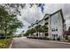 A street view of a well-maintained apartment building with neutral colors, lush greenery, and palm trees at 1216 S Missouri Ave # 108, Clearwater, FL 33756
