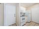 Compact kitchen featuring white appliances, granite countertops, and tile flooring near the entry door at 1216 S Missouri Ave # 108, Clearwater, FL 33756