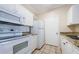 A well-maintained kitchen featuring white appliances, tile backsplash, and ample counter space at 1216 S Missouri Ave # 108, Clearwater, FL 33756