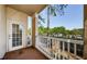 A large patio with a door, windows, white railing with treeline in the background at 1216 S Missouri Ave # 108, Clearwater, FL 33756
