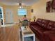 Bright living room with hardwood floors, featuring a dining table set for four and a red leather sofa at 1301 S Hercules Ave # 19, Clearwater, FL 33764
