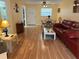 Bright living room with hardwood flooring, a dining table set for four, and a red leather sofa at 1301 S Hercules Ave # 19, Clearwater, FL 33764