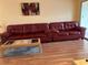 Well-lit living room with hardwood flooring, large red sofa, and stylish coffee table at 1301 S Hercules Ave # 19, Clearwater, FL 33764