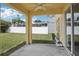 Covered back patio with ceiling fan and view to the fenced in yard at 13506 Copper Belly Ct, Riverview, FL 33569