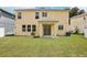 View of the backyard of the two story home with a covered patio at 13506 Copper Belly Ct, Riverview, FL 33569
