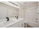 Bathroom with double sinks, modern black faucets, and tub with shower at 13506 Copper Belly Ct, Riverview, FL 33569
