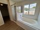 Bright bathroom featuring a soaking tub and a separate shower with a glass door at 13506 Copper Belly Ct, Riverview, FL 33569