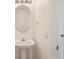 Clean bathroom featuring a pedestal sink, oval mirror, and white door at 13506 Copper Belly Ct, Riverview, FL 33569