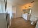 Bright bathroom featuring double sinks, white cabinets, and wood-look floors at 13506 Copper Belly Ct, Riverview, FL 33569