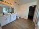 Bright bathroom featuring double sinks, modern lighting, and wood-look floors at 13506 Copper Belly Ct, Riverview, FL 33569