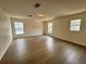 A bright bedroom with wood floors, multiple windows, and ample space at 13506 Copper Belly Ct, Riverview, FL 33569
