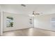 Bedroom features laminate floors, a ceiling fan, and large windows for natural light at 13506 Copper Belly Ct, Riverview, FL 33569