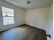 A cozy bedroom with wood floors and natural light from a window at 13506 Copper Belly Ct, Riverview, FL 33569