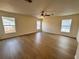 A spacious bedroom with wood flooring, three large windows, and a ceiling fan at 13506 Copper Belly Ct, Riverview, FL 33569