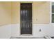 Close-up of a dark brown front door with classic panel design and modern hardware at 13506 Copper Belly Ct, Riverview, FL 33569