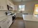 Well-lit kitchen features stainless appliances, bright white cabinets, and gorgeous quartz countertops at 13506 Copper Belly Ct, Riverview, FL 33569