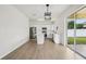 Bright kitchen has white cabinets, quartz countertops, island, stainless appliances, and sliding doors to patio at 13506 Copper Belly Ct, Riverview, FL 33569