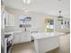 Bright kitchen features white cabinets, quartz countertops, island, stainless steel appliances, and sliding doors to patio at 13506 Copper Belly Ct, Riverview, FL 33569