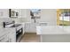 Bright kitchen features white cabinets, quartz countertops, island, and stainless steel appliances at 13506 Copper Belly Ct, Riverview, FL 33569