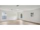 Bright living room with light wood floors and natural light from three windows at 13506 Copper Belly Ct, Riverview, FL 33569