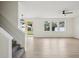 Bright living space with wood-look flooring, complemented by modern staircase and backyard access at 13506 Copper Belly Ct, Riverview, FL 33569