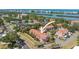 Aerial view of a residential area featuring lush greenery, red-roofed homes, and nearby waterfront views at 14506 Alejo Ct, Seminole, FL 33776