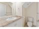 Half bath featuring granite countertops and a white vanity with sink and toilet at 14506 Alejo Ct, Seminole, FL 33776