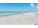 Expansive beach view with white sand, clear water, and blue skies perfect for relaxation and recreation at 14506 Alejo Ct, Seminole, FL 33776
