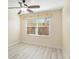 Cozy bedroom with a ceiling fan and a bright window view; features stylish laminate flooring at 14506 Alejo Ct, Seminole, FL 33776