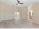 Large bedroom with ceiling fan, bright laminate flooring, and doorway to a full bathroom at 14506 Alejo Ct, Seminole, FL 33776