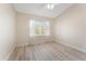Sunlit bedroom with wood-look flooring, ceiling fan, and large window dressed with sheers at 14506 Alejo Ct, Seminole, FL 33776