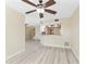 Open living area with ceiling fan, light wood flooring, and a view of the kitchen at 14506 Alejo Ct, Seminole, FL 33776