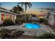 Lush backyard with a pool, spa, sun loungers, and mature landscaping for privacy at 146 8Th Ne Ave, St Petersburg, FL 33701