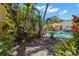 Secluded backyard with lush tropical landscaping, a glimpse of the pool, and sunny skies at 146 8Th Ne Ave, St Petersburg, FL 33701