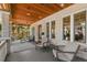 Inviting covered porch featuring stone columns, wood ceiling, and comfortable seating area at 146 8Th Ne Ave, St Petersburg, FL 33701