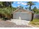 A two-car garage features a neutral palette, textured concrete driveway and a gabled roofline at 146 8Th Ne Ave, St Petersburg, FL 33701
