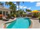 Backyard pool surrounded by lush landscaping with an umbrella covered table and lounge chairs at 146 8Th Ne Ave, St Petersburg, FL 33701