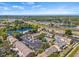 Aerial shot of the townhouse community, highlighting the lake, pool, and surrounding lush greenery under a bright sky at 1577 Chateaux De Ville Ct, Clearwater, FL 33764