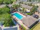 Aerial view of a community pool, palm trees and well-kept landscaping, offering a resort-like feel at 1577 Chateaux De Ville Ct, Clearwater, FL 33764