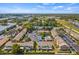 Aerial view featuring the townhouse community with a pool and pond surrounded by trees and well-maintained landscaping at 1577 Chateaux De Ville Ct, Clearwater, FL 33764