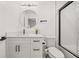 Modern bathroom featuring white vanity, round mirror, and black-trimmed shower, exuding clean, contemporary style at 1577 Chateaux De Ville Ct, Clearwater, FL 33764