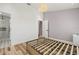 Bright bedroom featuring wood-look floors, a modern bed frame, and access to an adjacent bathroom and closet at 1577 Chateaux De Ville Ct, Clearwater, FL 33764