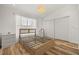 Bright bedroom with wood-look floors, showcasing a modern bed frame, closet, and ample natural light at 1577 Chateaux De Ville Ct, Clearwater, FL 33764