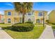 Attractive townhome featuring a lush front yard, sidewalk, and vibrant landscaping at 1577 Chateaux De Ville Ct, Clearwater, FL 33764