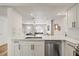 Modern kitchen with white cabinets, subway tile backsplash, and stainless steel dishwasher at 1577 Chateaux De Ville Ct, Clearwater, FL 33764