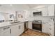 Bright kitchen features stainless steel appliances, white cabinets, and quartz countertops at 1577 Chateaux De Ville Ct, Clearwater, FL 33764