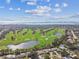 Beautiful aerial view of a golf course community with lush landscaping, a pond, water views and a skyline at 1714 Cypress Ave, Belleair, FL 33756