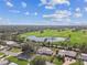 Expansive aerial view of a verdant golf course community with mature trees, a peaceful pond, and blue skies at 1714 Cypress Ave, Belleair, FL 33756