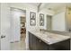 A bright bathroom features a marble countertop vanity, decorative wall art, and mirrors with views into other rooms at 1714 Cypress Ave, Belleair, FL 33756