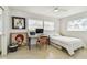 Sunlit bedroom features modern desk, artwork, ceiling fan, and windows that let in natural light at 1714 Cypress Ave, Belleair, FL 33756